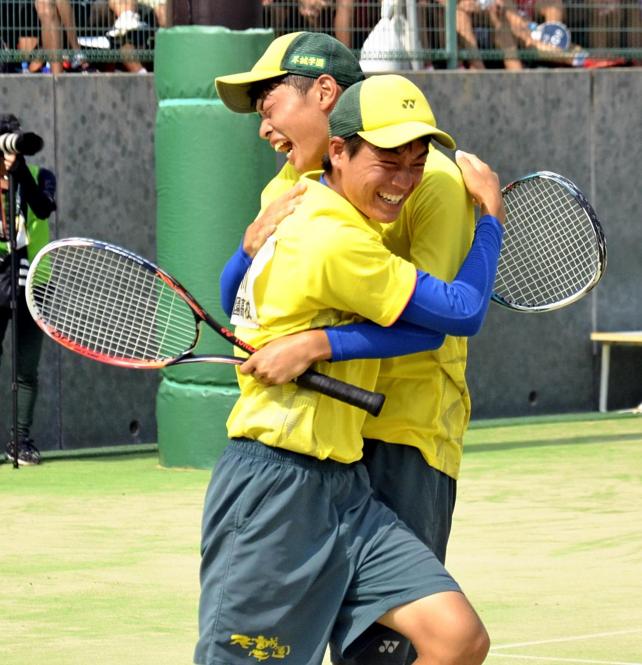 ソフトテニス男子個人（ダブルス）で優勝を決めて抱き合う尽誠学園の白川雄己（手前）、石川峻伍組（27日、宮崎市で）＝小沢理貴撮影