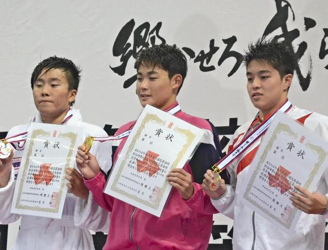 競泳男子200メートル個人メドレーの表彰式で笑顔を見せる日大の小方選手(中央)
