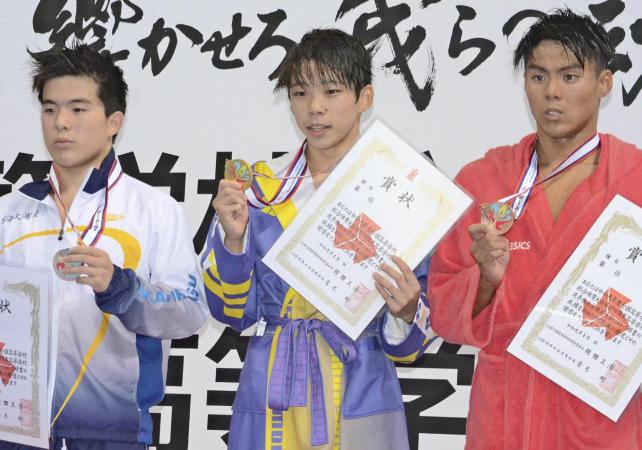 競泳男子200メートルバタフライで優勝し、表彰台で笑顔を見せる昭和学院の寺門選手(中央)と、準優勝した東海大浦安の井上選手(左)