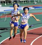 陸上女子４００メートルリレーで３位に入った山形中央の第２走者・青野朱李（左）から第３走者・青野心音へのバトンタッチ　©読売新聞社