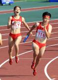 陸上女子400メートルリレーで優勝した立命館慶祥の第2走者・臼井文音(左)から第3走者・石堂陽奈へのバトンタッチ ©読売新聞社