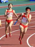 陸上女子４００メートルリレーで優勝した立命館慶祥の第２走者・臼井文音（左）から第３走者・石堂陽奈へのバトンタッチ　©読売新聞社