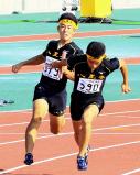 陸上男子400メートルリレーで優勝した八王子の第2走者・斎藤陸人(左)から第3走者・上野弘貴へのバトンタッチ ©読売新聞社