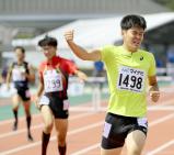 男子400メートル障害を制し、拳を突き上げる東福岡の出口晴翔選手(右)