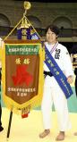 柔道女子70キロ級 姉・七海の名前が入った優勝旗を手に笑顔を見せる桐蔭学園の朝飛真実選手