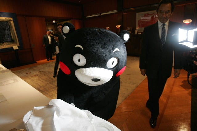 こらこら。まだパーティーは始まってないよ。ディナーのお皿を取ろうとするくまモン撮影:山口和幸