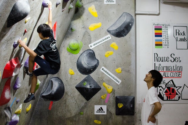 壁を登る子どもを見守る安間佐千さん撮影:五味渕秀行