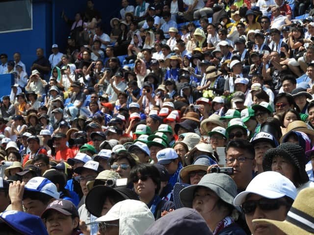 スタンドからは多くの人が行進を見守る撮影：手束仁