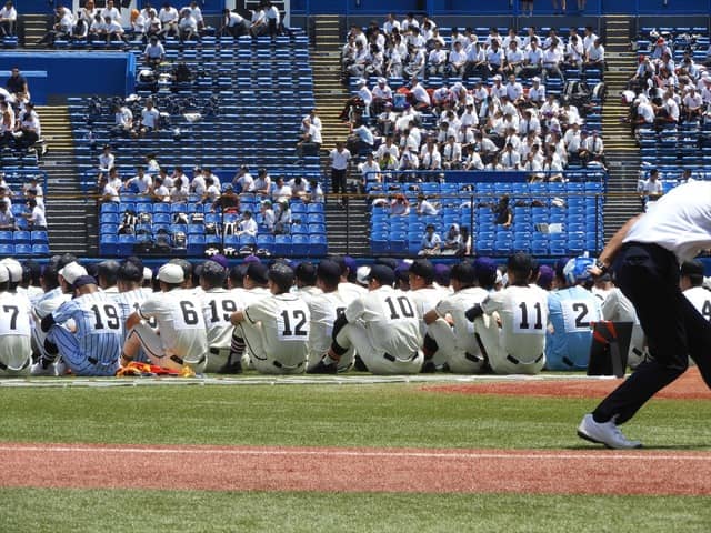 式後、全員が人工芝に座って、オーロラビジョンを見つめる撮影：手束仁