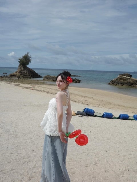 菅田愛貴、「海と笑顔が溶け合う夏」。赤い花飾りと振り向き美に視線釘付け