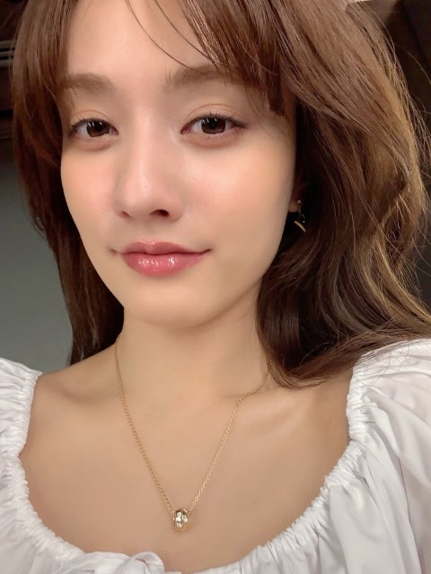 谷まりあの艶やか微笑みに癒やされる週末、白ブラウスとゴールドの輝きが静かに心をほどく