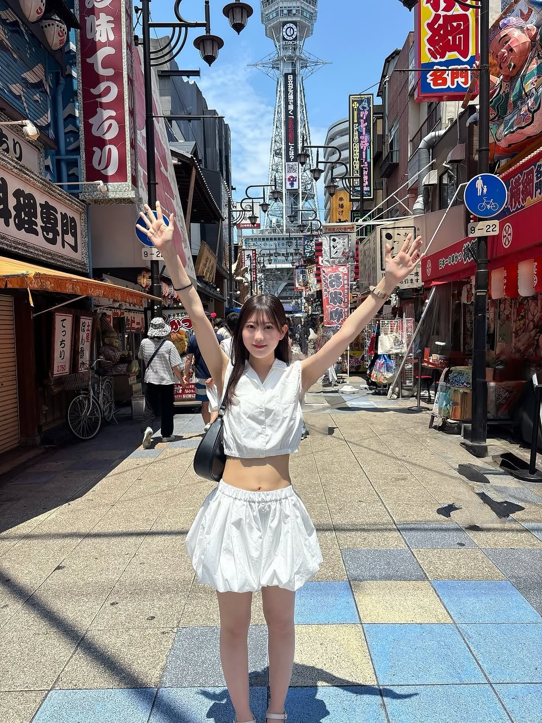 サービスショットにファン悶絶⁉現役女子大生リケジョタレント美女子、通天閣バックにヘソ出しスマイルショット！